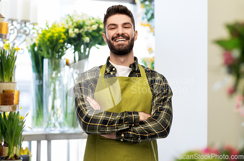 Image of happy young male seller in apron at flower shop