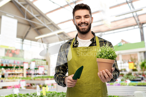 Image of gardener or seller with trowel at flower shop