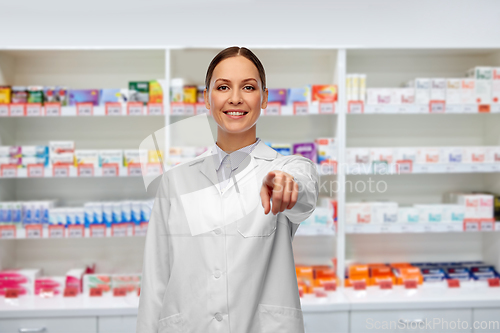 Image of female pharmacist pointing to camera at pharmacy