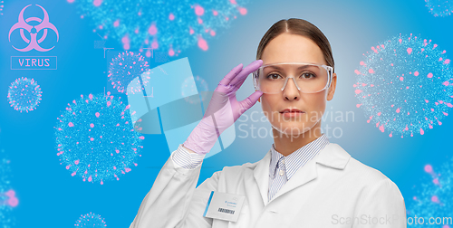 Image of female scientist in goggles and gloves over virus