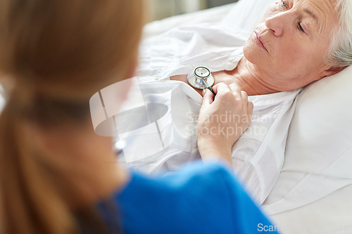 Image of doctor with stethoscope and old woman at hospital