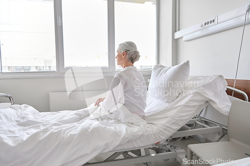 Image of lonely senior woman sitting in bed at hospital