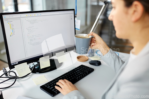 Image of businesswoman with computer and coffee at office