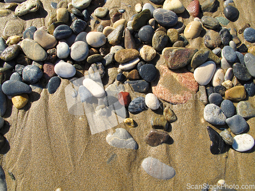 Image of Wet sea pebbles on the sand