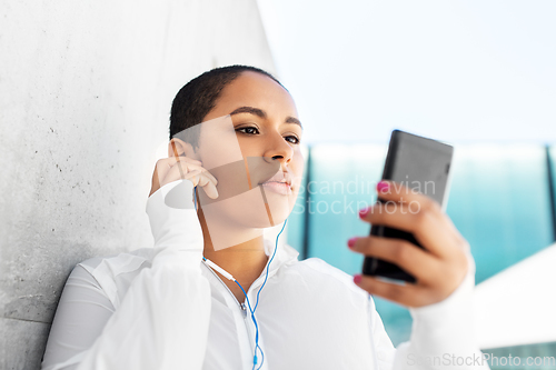 Image of african american woman with earphones and phone