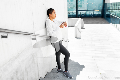 Image of african woman with earphones and smart watch