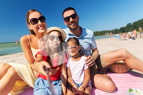 Image of happy family taking selfie on summer beach