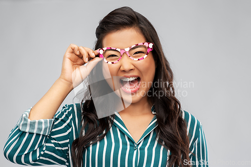Image of happy asian woman with party glasses