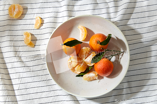 Image of still life with mandarins on plate over drapery