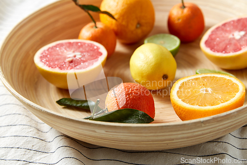 Image of close up of citrus fruits on wooden plate