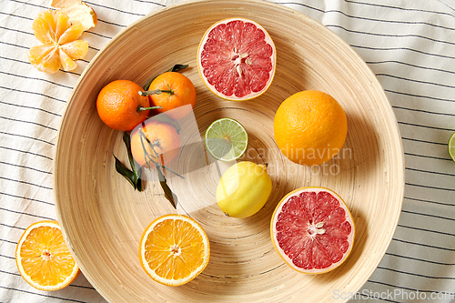 Image of close up of citrus fruits on wooden plate