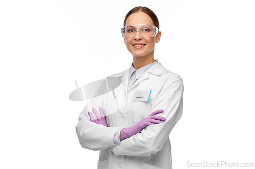 Image of smiling female scientist in goggles and gloves