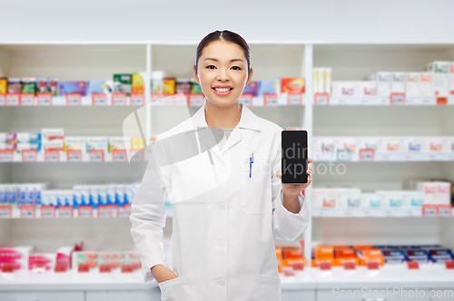 Image of asian pharmacist with smartphone at pharmacy