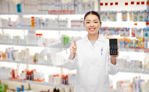 Image of asian pharmacist with phone shows thumbs up