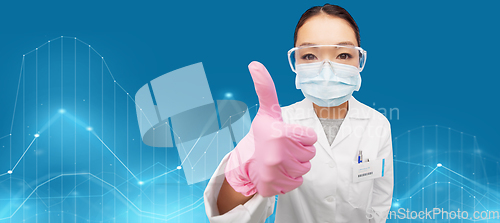 Image of asian female doctor in mask showing thumbs up