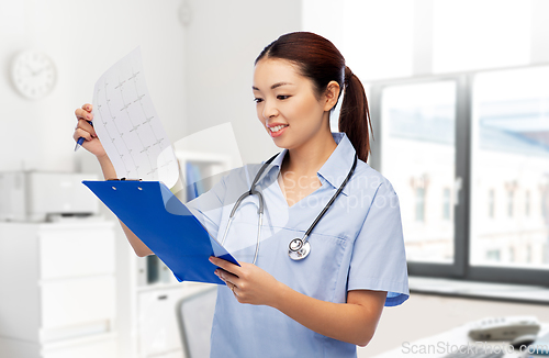 Image of asian female doctor with cardiogram at hospital