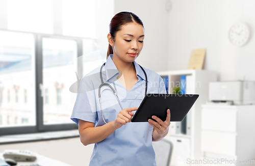 Image of asian female nurse with tablet pc at hospital