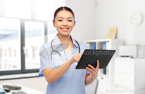 Image of asian female nurse with tablet pc at hospital