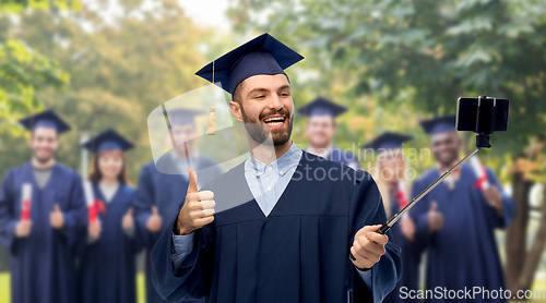 Image of male graduate student with smartphone takes selfie