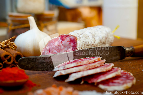 Image of traditional Italian salame cured sausage sliced on a wood board