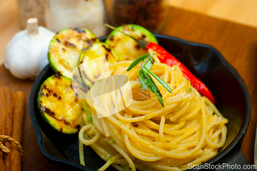 Image of italian spaghetti pasta with zucchini sauce on iron skillet