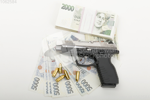 Image of gun and czech banknotes, crime concept