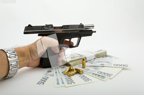 Image of gun and czech banknotes, crime concept