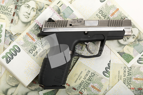 Image of gun and czech banknotes, crime concept