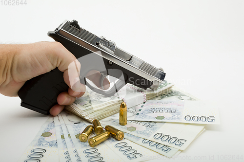 Image of gun and czech banknotes, crime concept