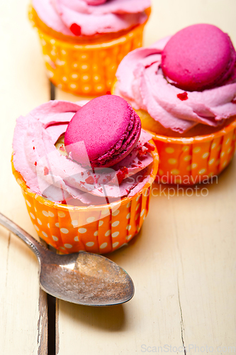 Image of pink berry cream cupcake with macaroon on top