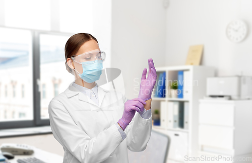 Image of female doctor in gloves, mask and goggles