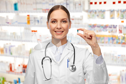 Image of female doctor holding medicine pill at pharmacy