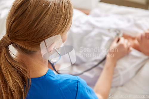 Image of doctor with stethoscope and old woman at hospital