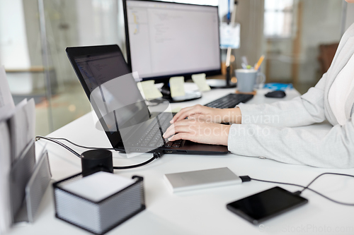 Image of businesswoman with laptop working at office