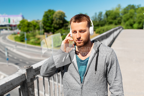 Image of man in headphones listening to music outdoors