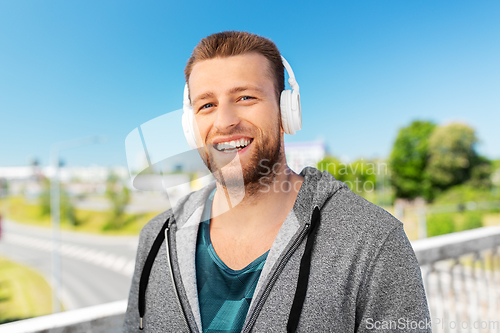 Image of happy smiling man in headphones listening to music
