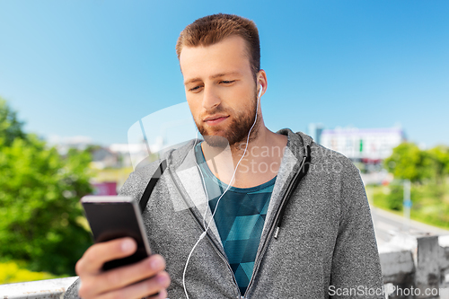 Image of young man with earphones and smartphone