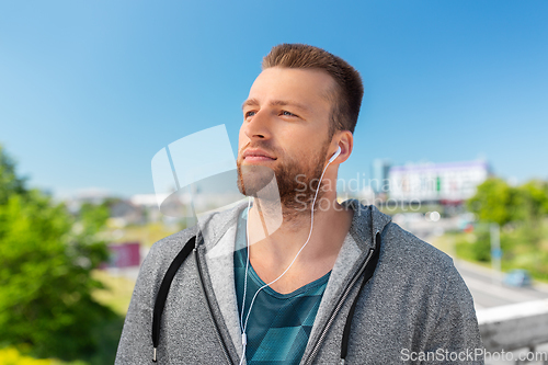 Image of man in earphones listening to music outdoors