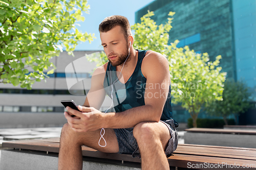 Image of young athlete man with earphones and smartphone