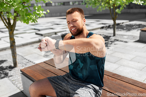 Image of man with smart watch sitting on bench