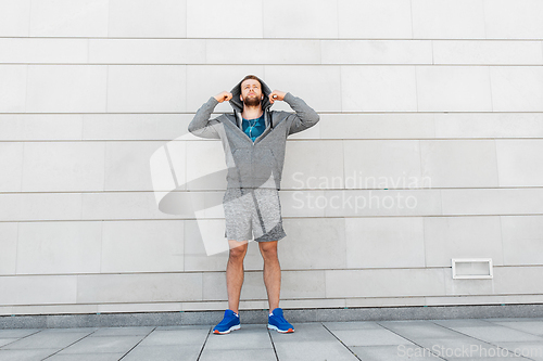 Image of man in earphones listening to music outdoors