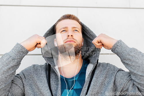 Image of man in earphones listening to music outdoors