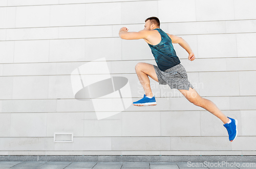 Image of young man running or jumping outdoors