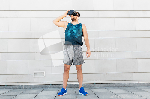 Image of young man in sports clothes with vr glasses