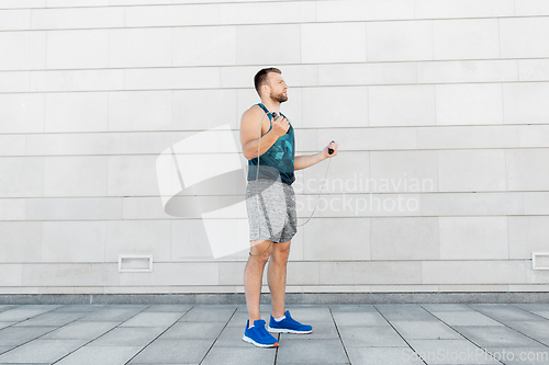 Image of man exercising with jump-rope outdoors