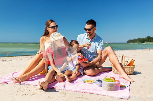 Image of happy family having picnic on summer beach