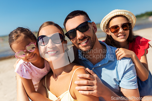 Image of happy family in sunglasses on summer beach