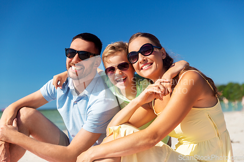 Image of family hugging on summer beach