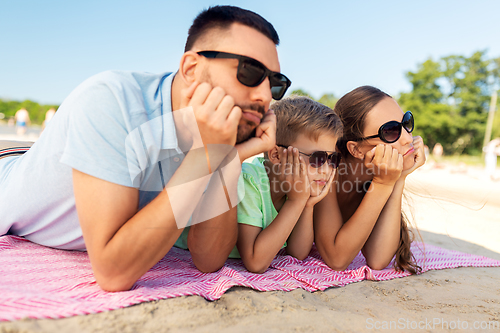 Image of family lying on summer beach