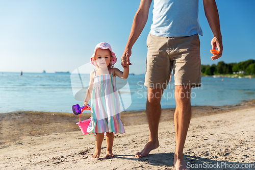 Image of father walking with little daughter on beach